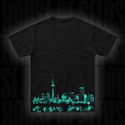 Das Doja T-Shirt Berlin Green von Doja zeigt eine leuchtend grüne Skyline der Stadt auf dem unteren Rücken.